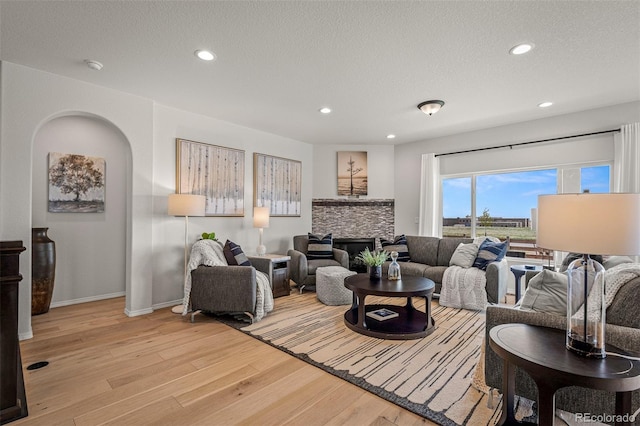 13410 New Ranch Dr, Peyton, CO 80831 - living room with light wood-type flooring, recessed lighting, baseboards, a textured ceiling, and arched walkways