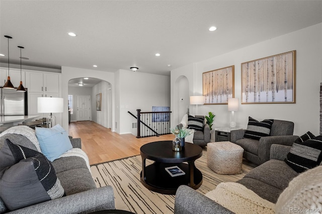 13410 New Ranch Dr, Peyton, CO 80831 - living area with arched walkways, recessed lighting, and light wood-style flooring