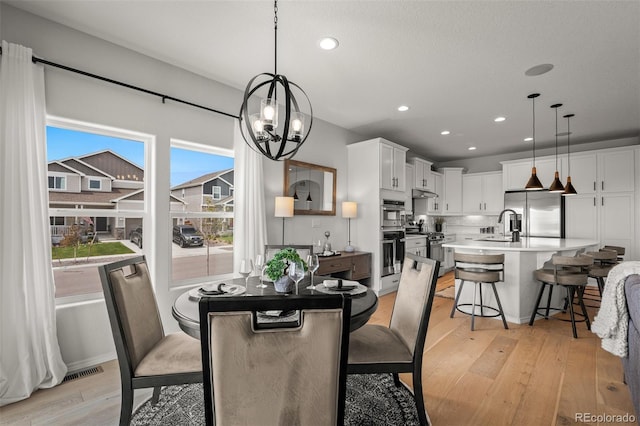 13410 New Ranch Dr, Peyton, CO 80831 - dining space featuring light wood finished floors, recessed lighting, and a chandelier