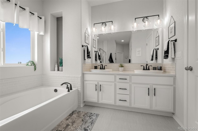 13410 New Ranch Dr, Peyton, CO 80831 - bathroom featuring double vanity, a garden tub, and backsplash