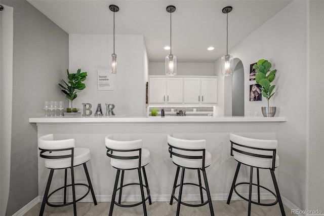 13410 New Ranch Dr, Peyton, CO 80831 - kitchen featuring white cabinets, a breakfast bar area, hanging light fixtures, and recessed lighting