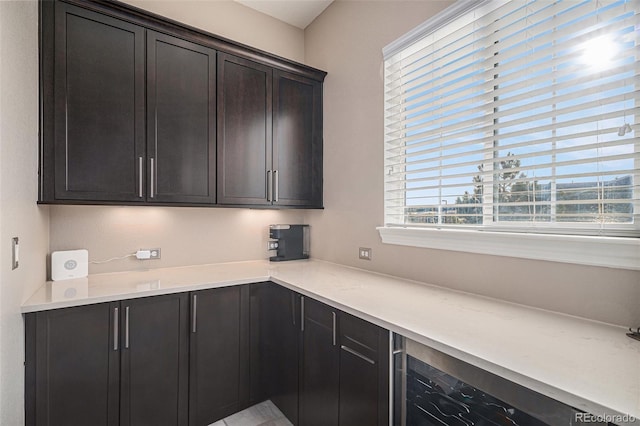 kitchen featuring wine cooler and dark brown cabinets