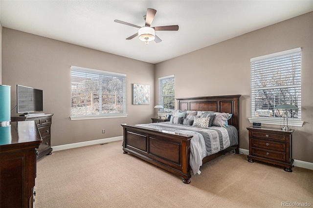 bedroom with light carpet, multiple windows, and ceiling fan