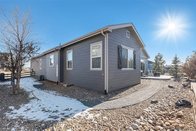 snow covered property featuring central AC unit