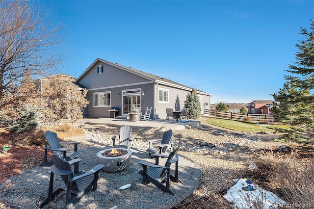 rear view of property with a patio and an outdoor fire pit