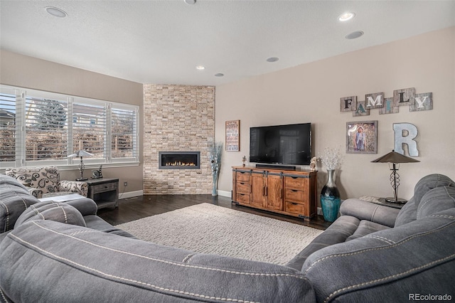 living room featuring a fireplace, dark hardwood / wood-style floors, and a textured ceiling