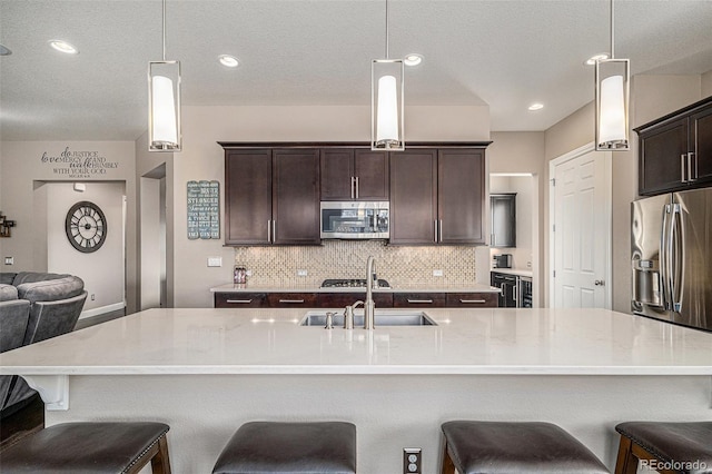 kitchen featuring decorative light fixtures, a spacious island, and appliances with stainless steel finishes