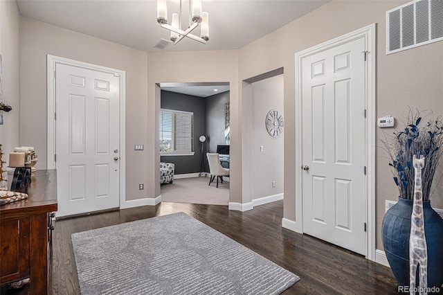 entryway featuring dark wood-type flooring and a chandelier