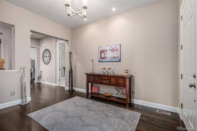 foyer entrance featuring dark wood-type flooring and a chandelier