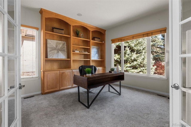 home office featuring light carpet, visible vents, a healthy amount of sunlight, and baseboards