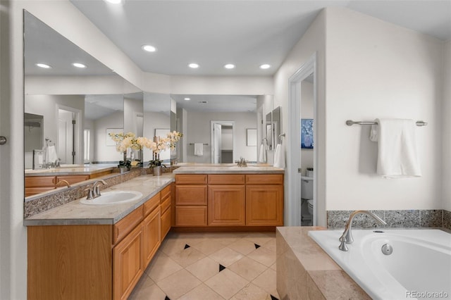 full bathroom with double vanity, toilet, a garden tub, and a sink