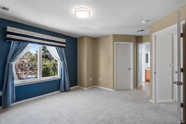 carpeted spare room with baseboards and visible vents