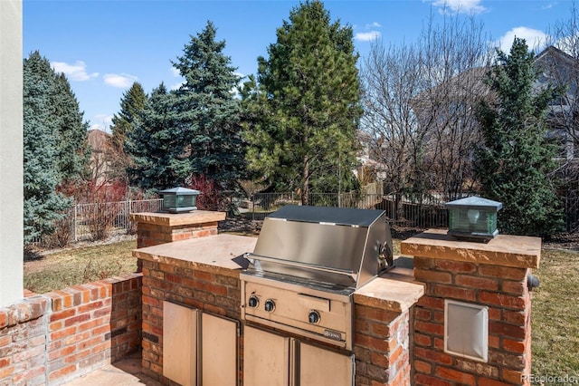 view of patio with area for grilling, an outdoor kitchen, and a fenced backyard