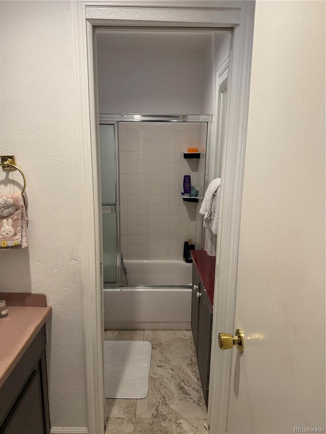 bathroom with vanity and bath / shower combo with glass door