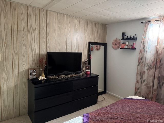 carpeted bedroom featuring wooden walls