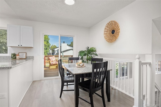 18527 E Kansas Pl, Aurora, CO 80017 - dining space featuring light wood-type flooring and a textured ceiling