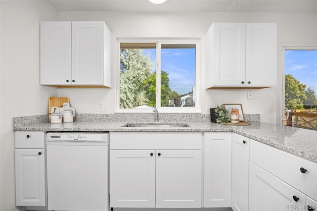 18527 E Kansas Pl, Aurora, CO 80017 - kitchen with white dishwasher, white cabinetry, healthy amount of natural light, and light stone countertops