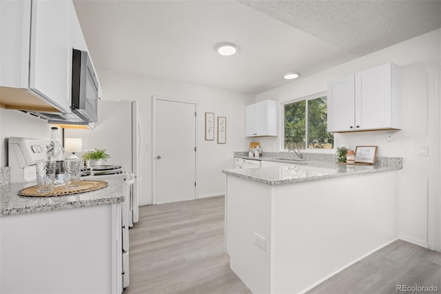 18527 E Kansas Pl, Aurora, CO 80017 - kitchen with light wood-style floors, white cabinets, and a peninsula