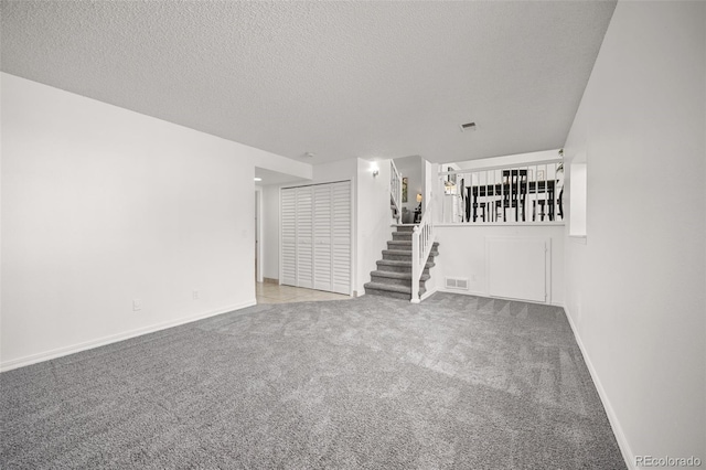 18527 E Kansas Pl, Aurora, CO 80017 - empty room featuring carpet flooring, stairs, and a textured ceiling
