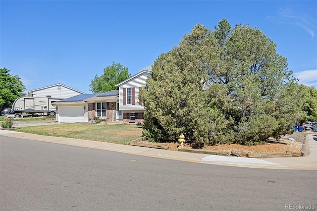 18527 E Kansas Pl, Aurora, CO 80017 - tri-level home featuring solar panels, an attached garage, brick siding, a front lawn, and concrete driveway