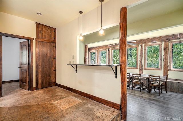 kitchen featuring decorative light fixtures, wood finished floors, and baseboards