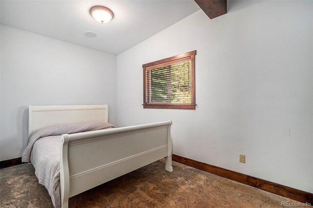 bedroom featuring vaulted ceiling with beams and baseboards