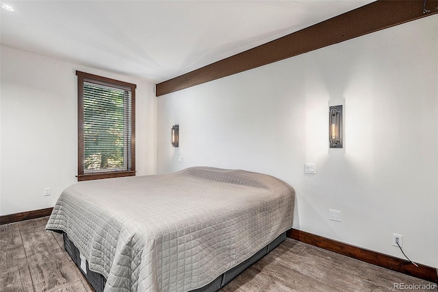 bedroom featuring wood finished floors and baseboards