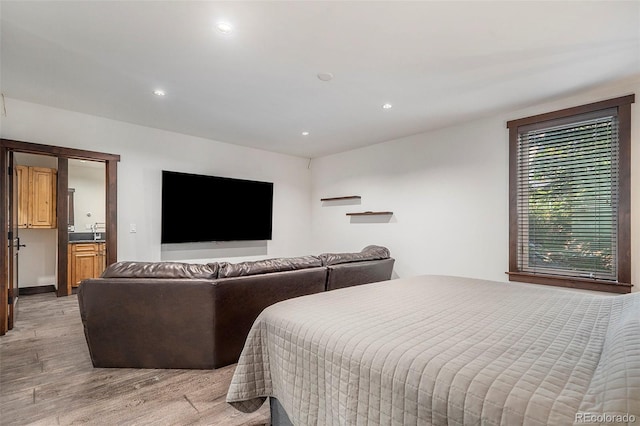 bedroom with recessed lighting, light wood-style flooring, and a sink