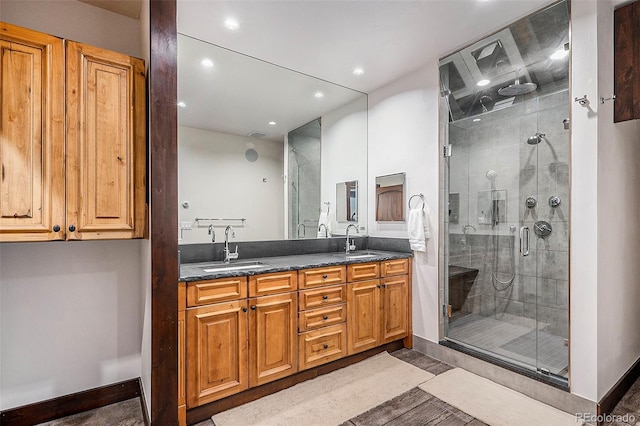 full bathroom with a sink, a stall shower, and double vanity