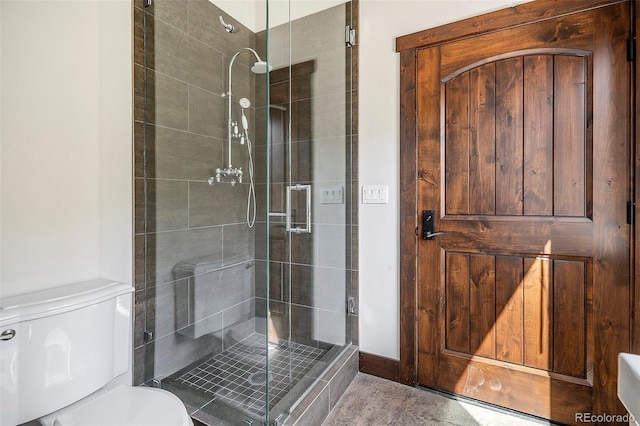 bathroom with a shower stall and toilet