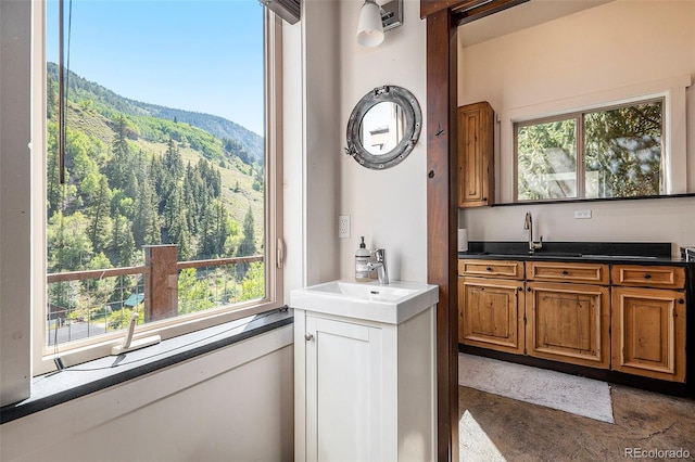 bar featuring a mountain view, concrete flooring, and a sink