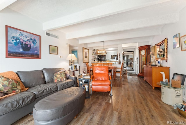 living room featuring a textured ceiling, beamed ceiling, and dark hardwood / wood-style floors