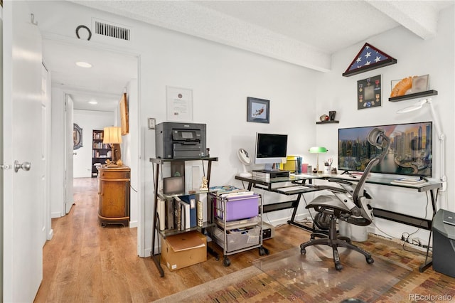 office featuring hardwood / wood-style flooring, beam ceiling, and a textured ceiling