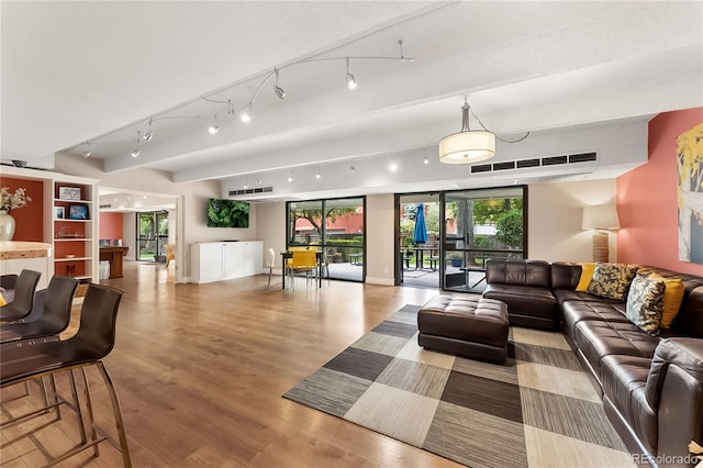 interior space with light hardwood / wood-style floors, track lighting, and a textured ceiling