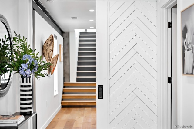 hall with recessed lighting, light wood-type flooring, and baseboards