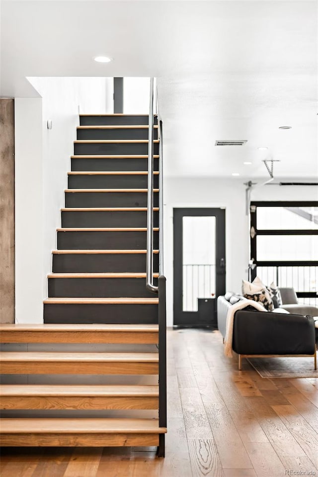 stairs featuring hardwood / wood-style flooring and visible vents