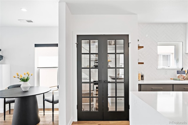 interior space with french doors, visible vents, and wood finished floors