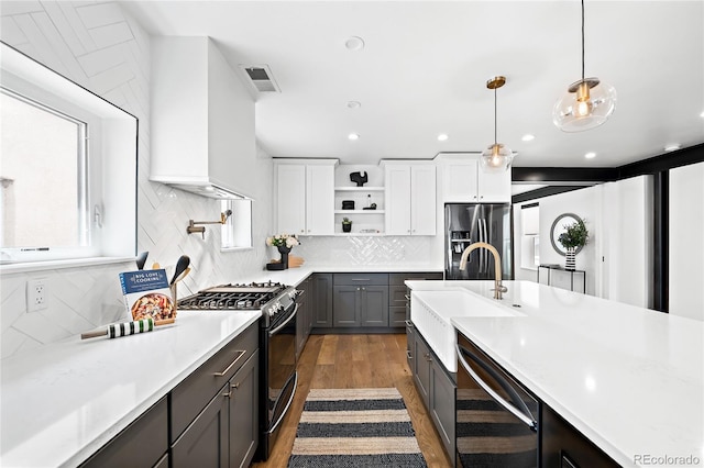 kitchen with stainless steel refrigerator with ice dispenser, a sink, gas range oven, light countertops, and dishwashing machine