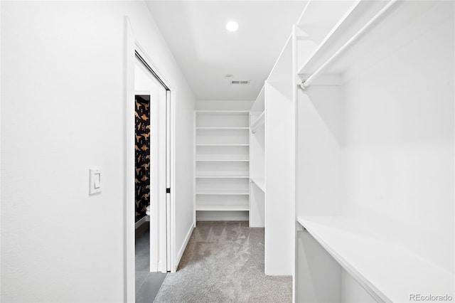 spacious closet featuring visible vents and light colored carpet