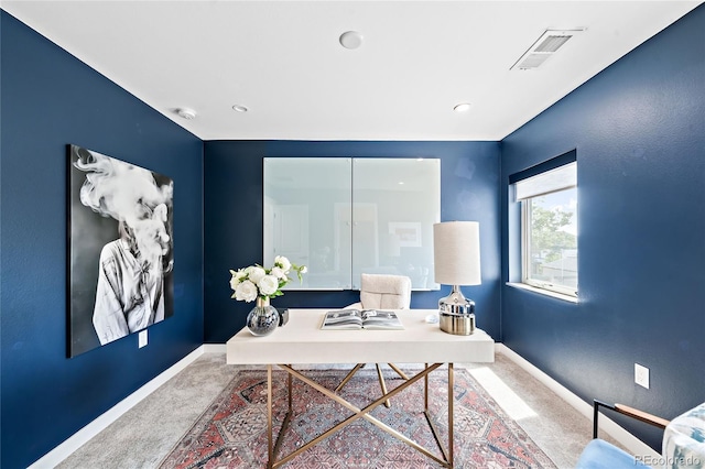 carpeted office space featuring visible vents and baseboards