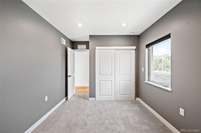 unfurnished bedroom featuring recessed lighting, a closet, baseboards, and carpet floors