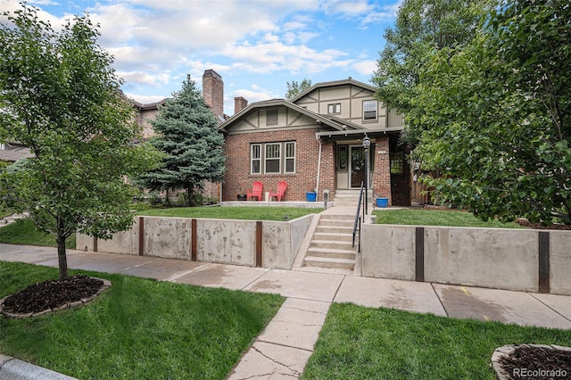 726 S Corona St, Denver, CO 80209 - tudor-style house with brick siding, a front yard, and a chimney