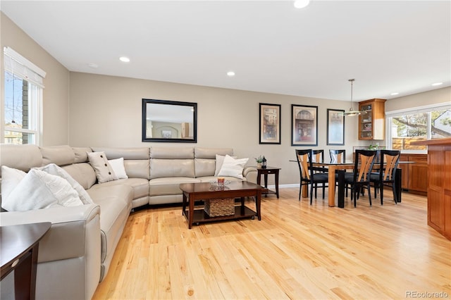 living area featuring recessed lighting, baseboards, and light wood finished floors