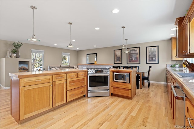 kitchen featuring light countertops, recessed lighting, light wood-type flooring, and appliances with stainless steel finishes