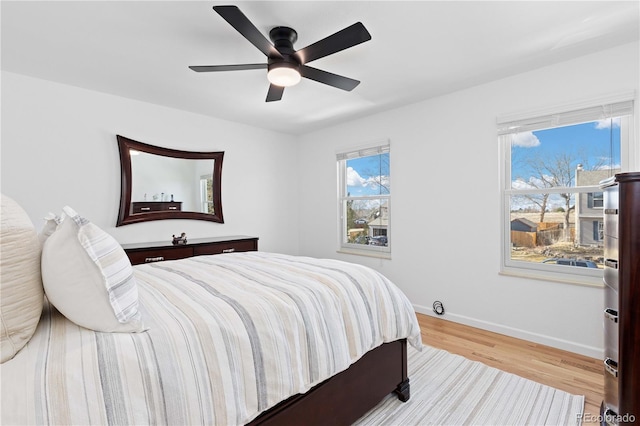 bedroom with baseboards, wood finished floors, and a ceiling fan