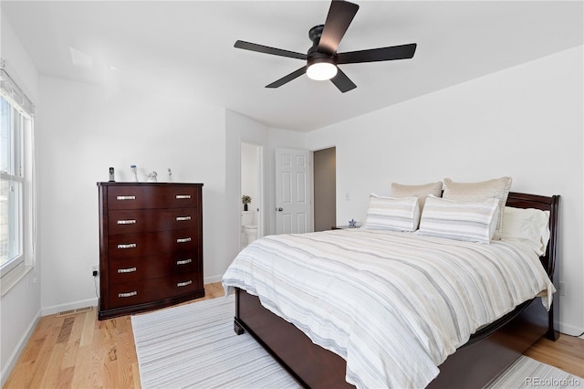 bedroom with visible vents, connected bathroom, ceiling fan, baseboards, and light wood-style floors