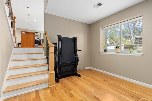 stairs with visible vents, baseboards, and wood finished floors