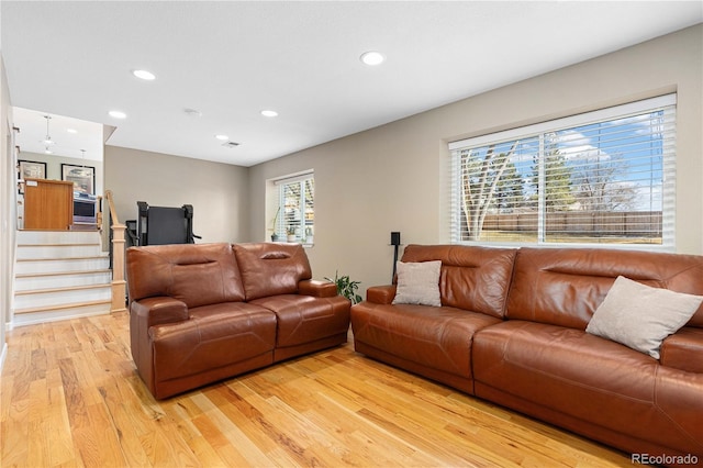 living room featuring stairs, recessed lighting, and light wood finished floors