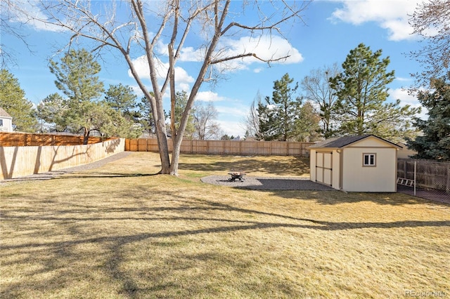 view of yard featuring a storage shed, an outbuilding, a fenced backyard, and a fire pit