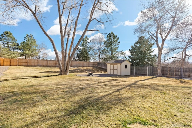 view of yard with an outdoor structure, a fenced backyard, and a shed